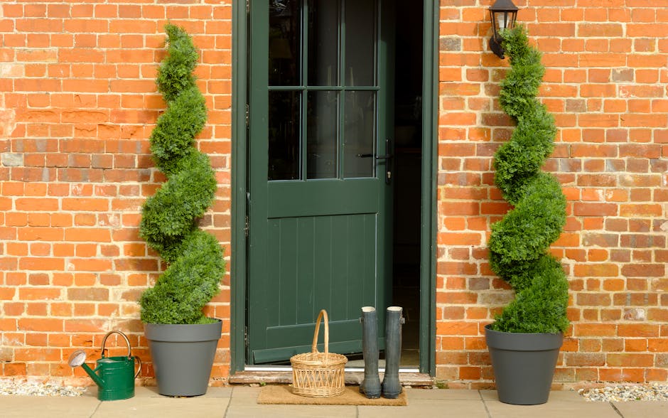 Blooming Artificial cedar spiral topiary trees outside green front door