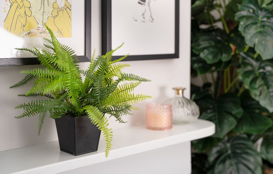 Artificial fern bush on white mantelpiece