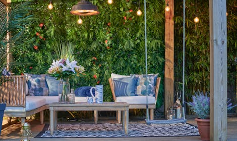 Artificial outdoor seating area with faux bouquet and artificial green wall