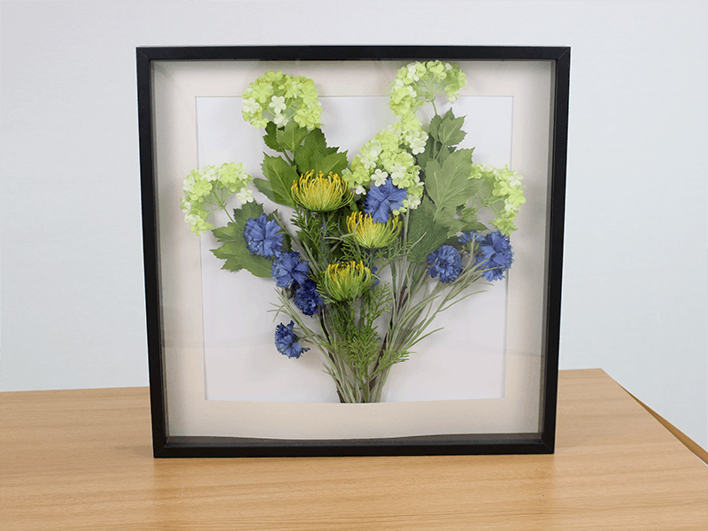 Artificial flowers in photo frame