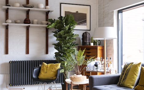 Two artificial plants in the corner of a living room