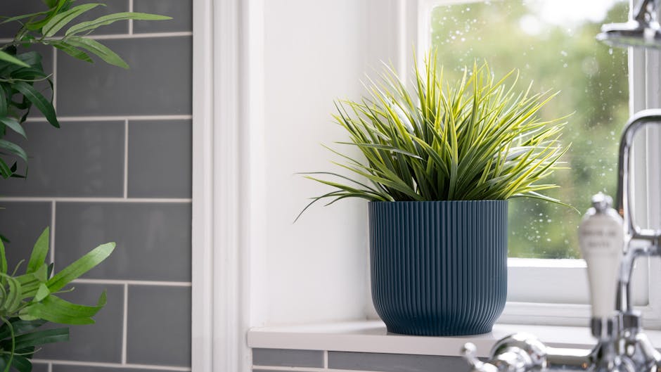 Artificial grass bush on bathroom window sill