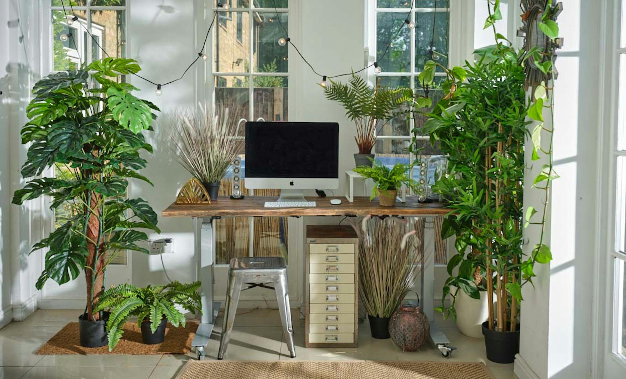 Artificial plants surrounding desk space