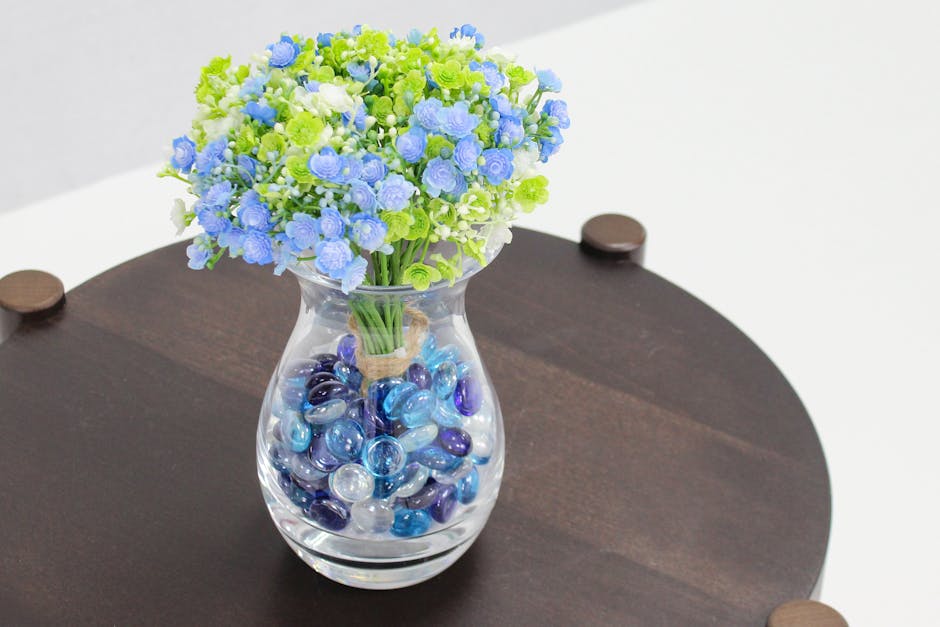 Artificial blue glass pebbles in flower vase