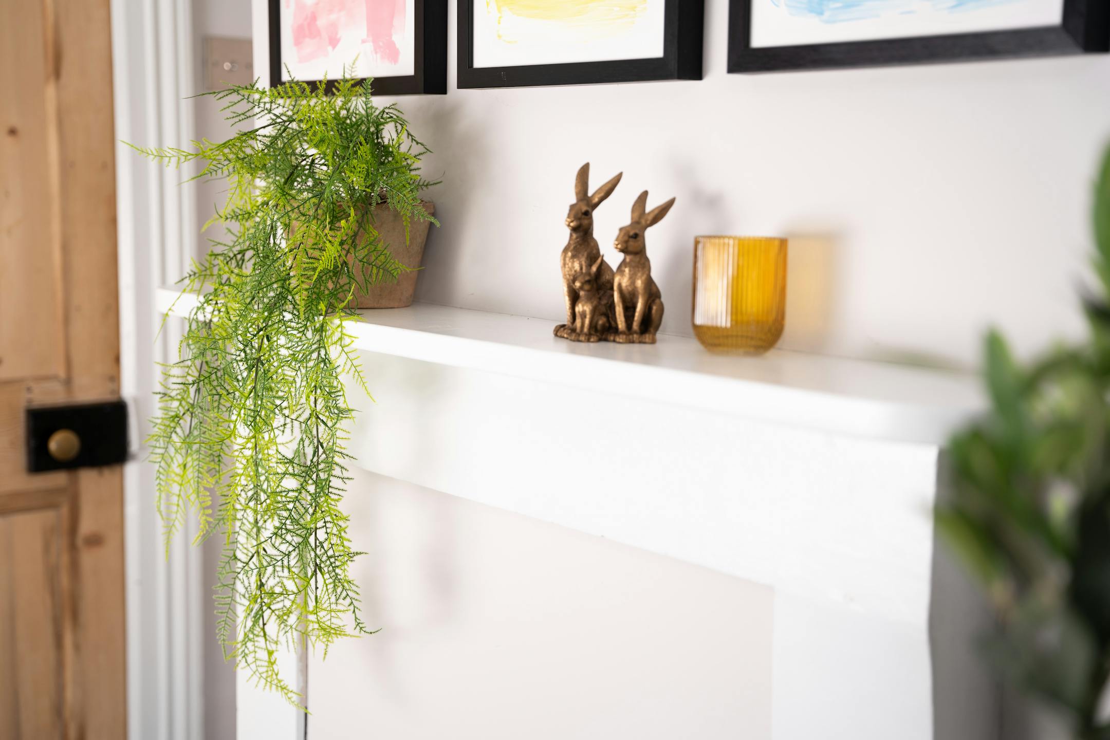 hanging plumous fern next to bronze hare ornamnet