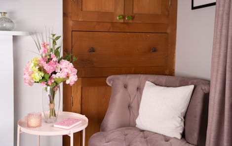 Faux pink passion flower bunch with pink velvet chair