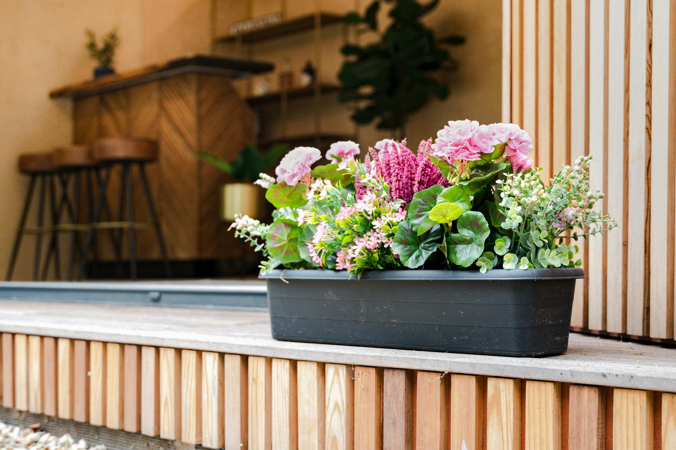 Artificial summer shine window box outside wooden garden cabin