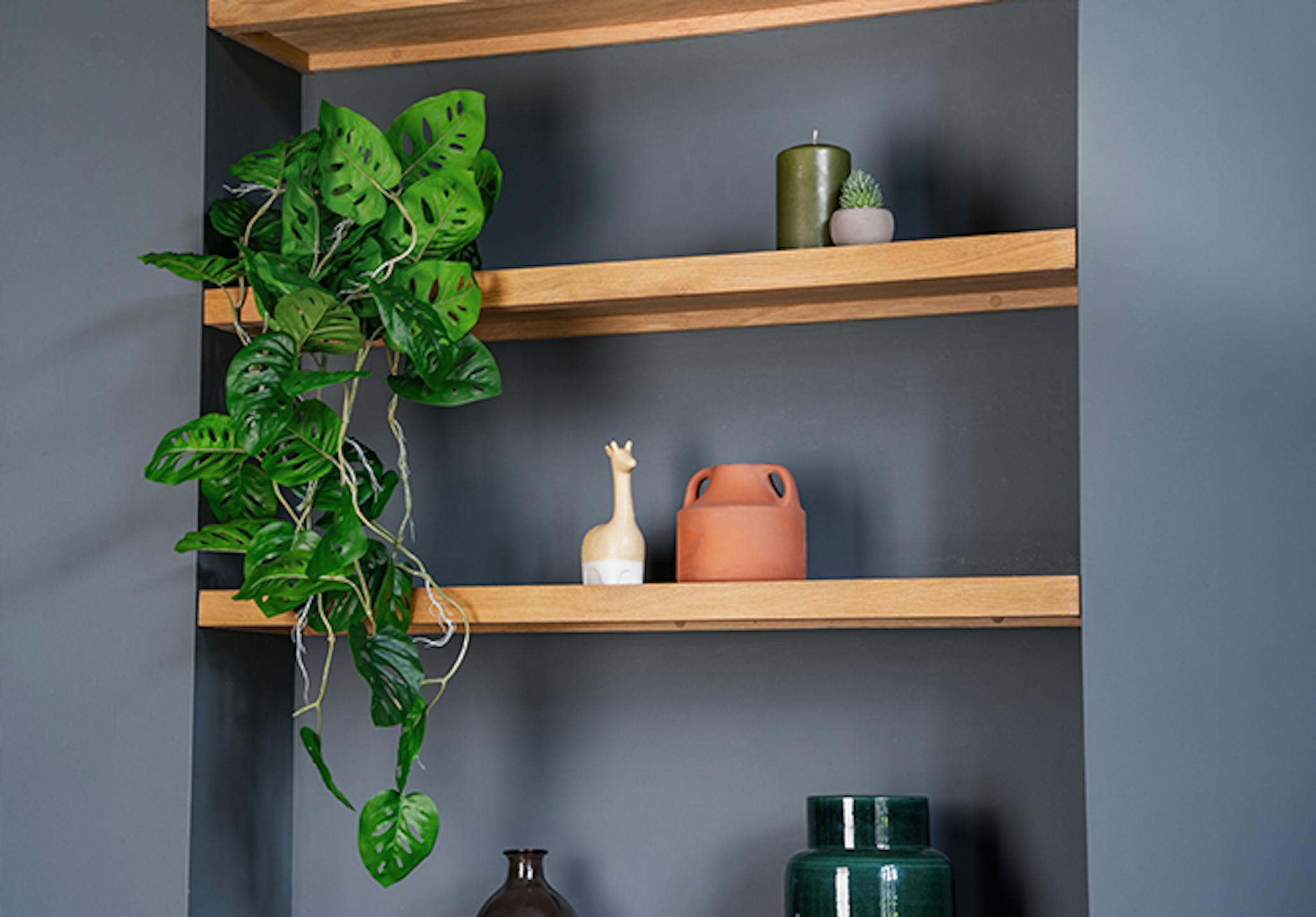 Artificial monkey monstera garland trailing down shelves