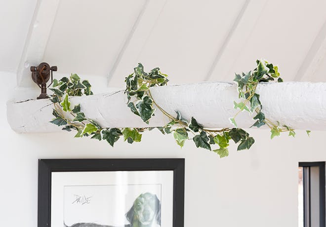 Faux variegated ivy garland on white wooden beam