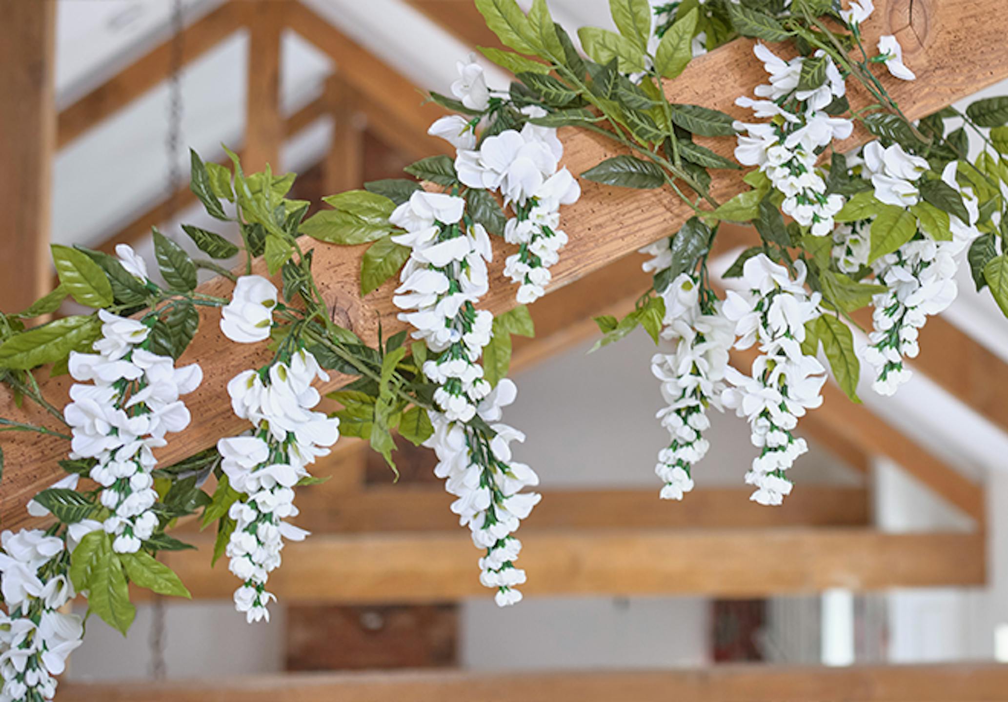Faux white wisteria garland on wooden beam