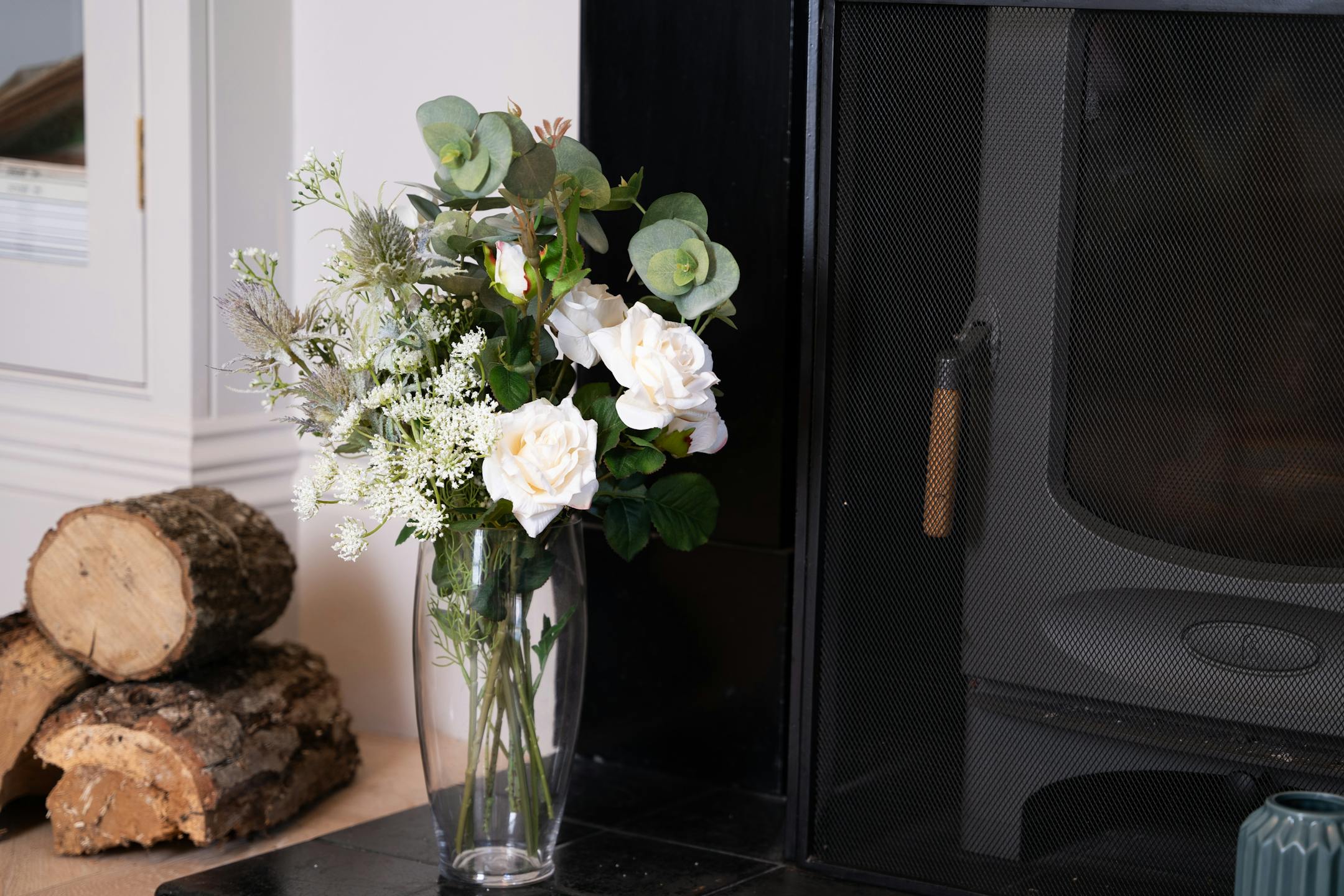 Artificial enchanting bunch of flowers on fireplace hearth
