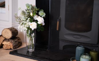 Artificial enchanting bunch of flowers on fireplace hearth