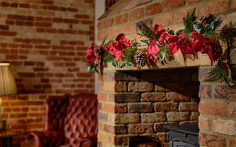 Artificial festive poinsettia fiesta-style garland over fireplace