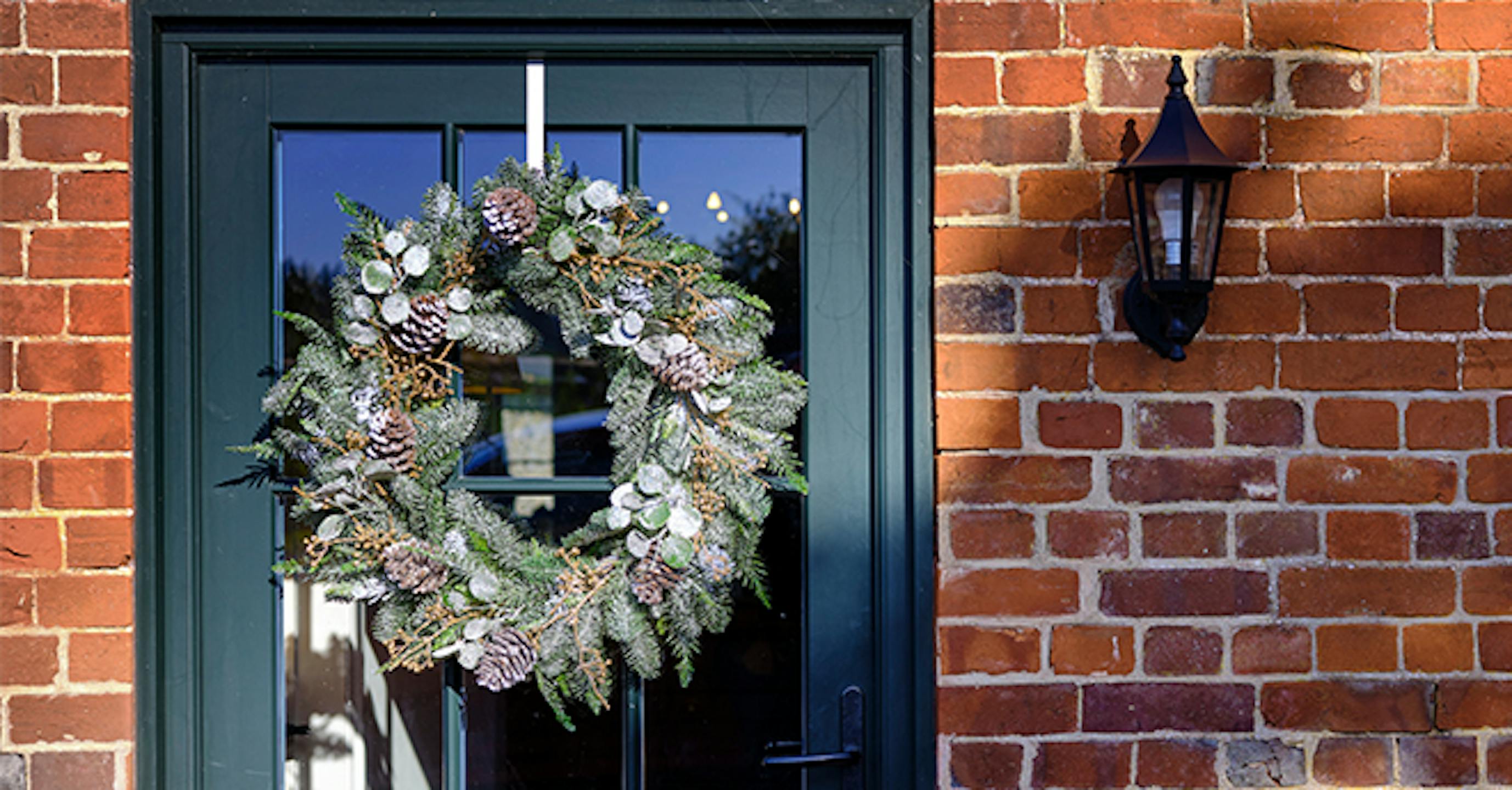 Christmas winter wreath hanging on green door