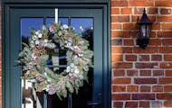 Christmas winter wreath hanging on green door