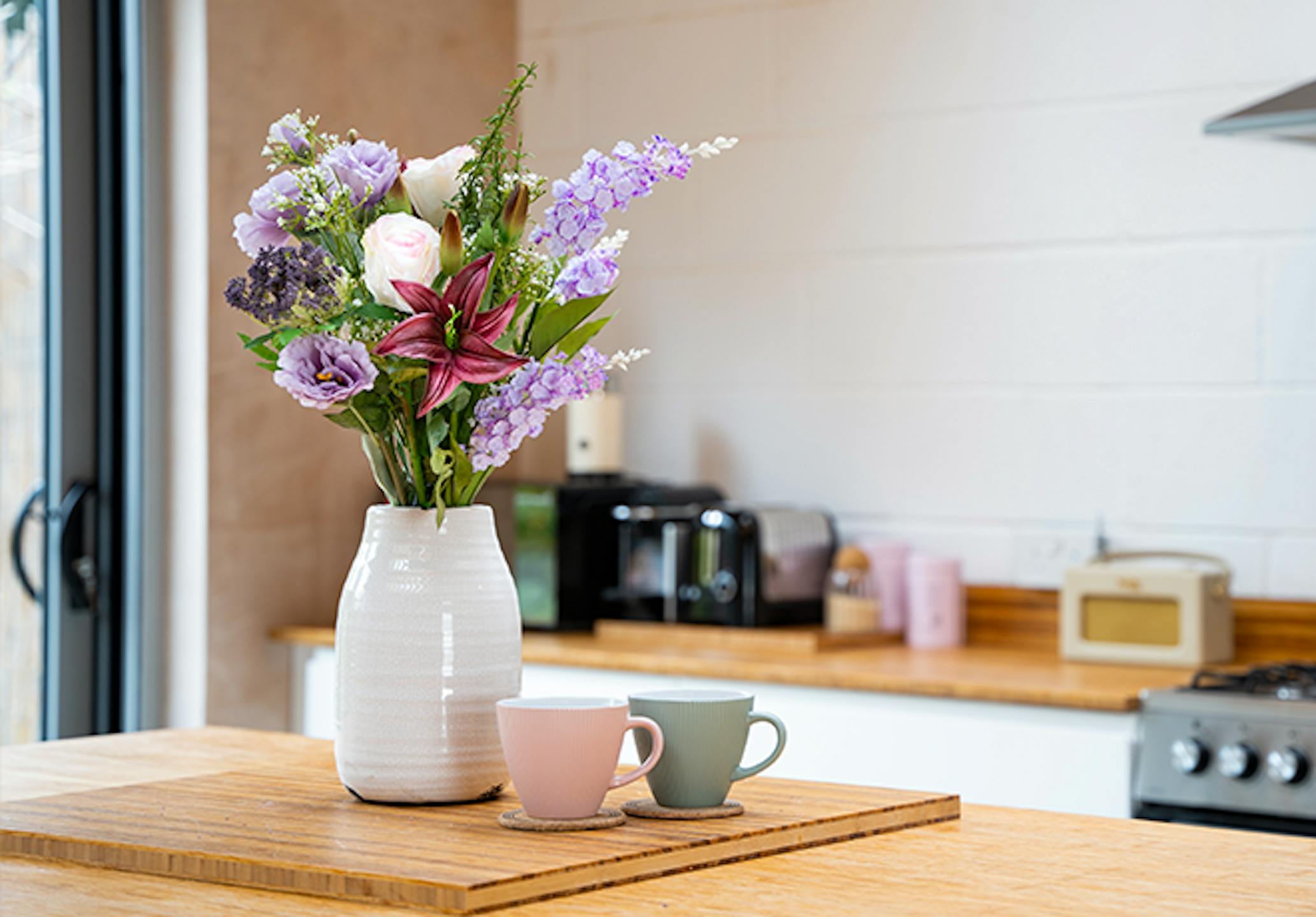 Artificial lilac bunch on wooden kitchen island