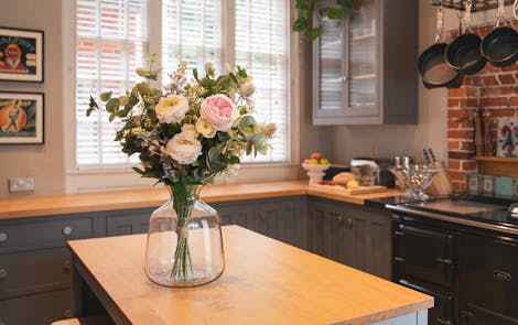 Artificial harmony bouquet on wooden kitchen island