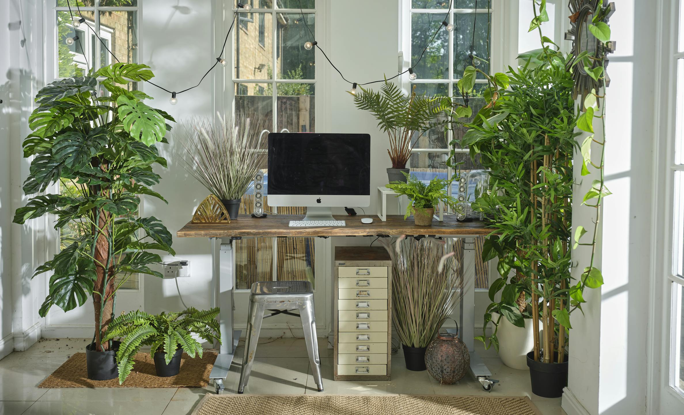 Jungle of artificial exotic plants surrounding home office space