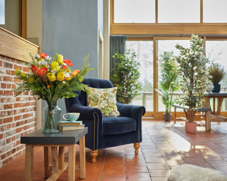 Artificial spring bouquet in blue and red brick lounge next to blue armchair
