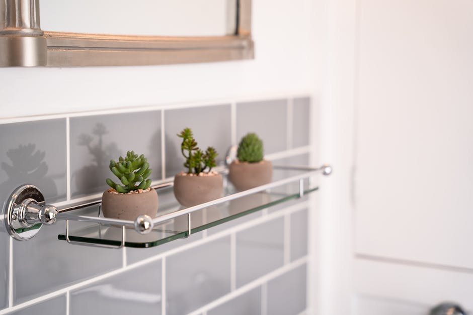 Mini artificial succulents on shelf in grey bathroom
