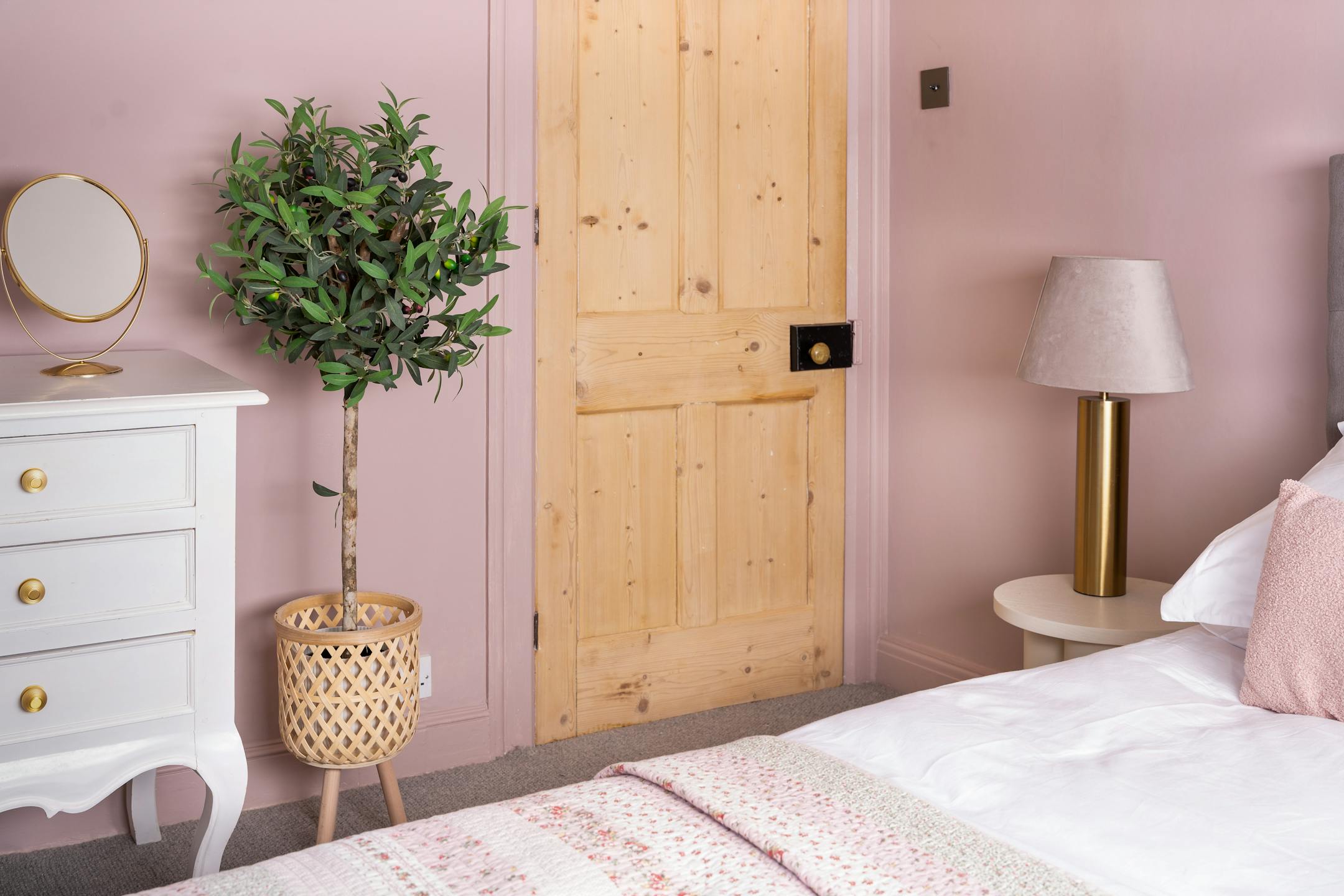 Artificial olive ball tree in wooden plant stand in pink bedroom