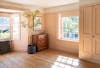 Artificial mahonia fortunei tree in pink bedroom with wooden floorboards and wooden dresser