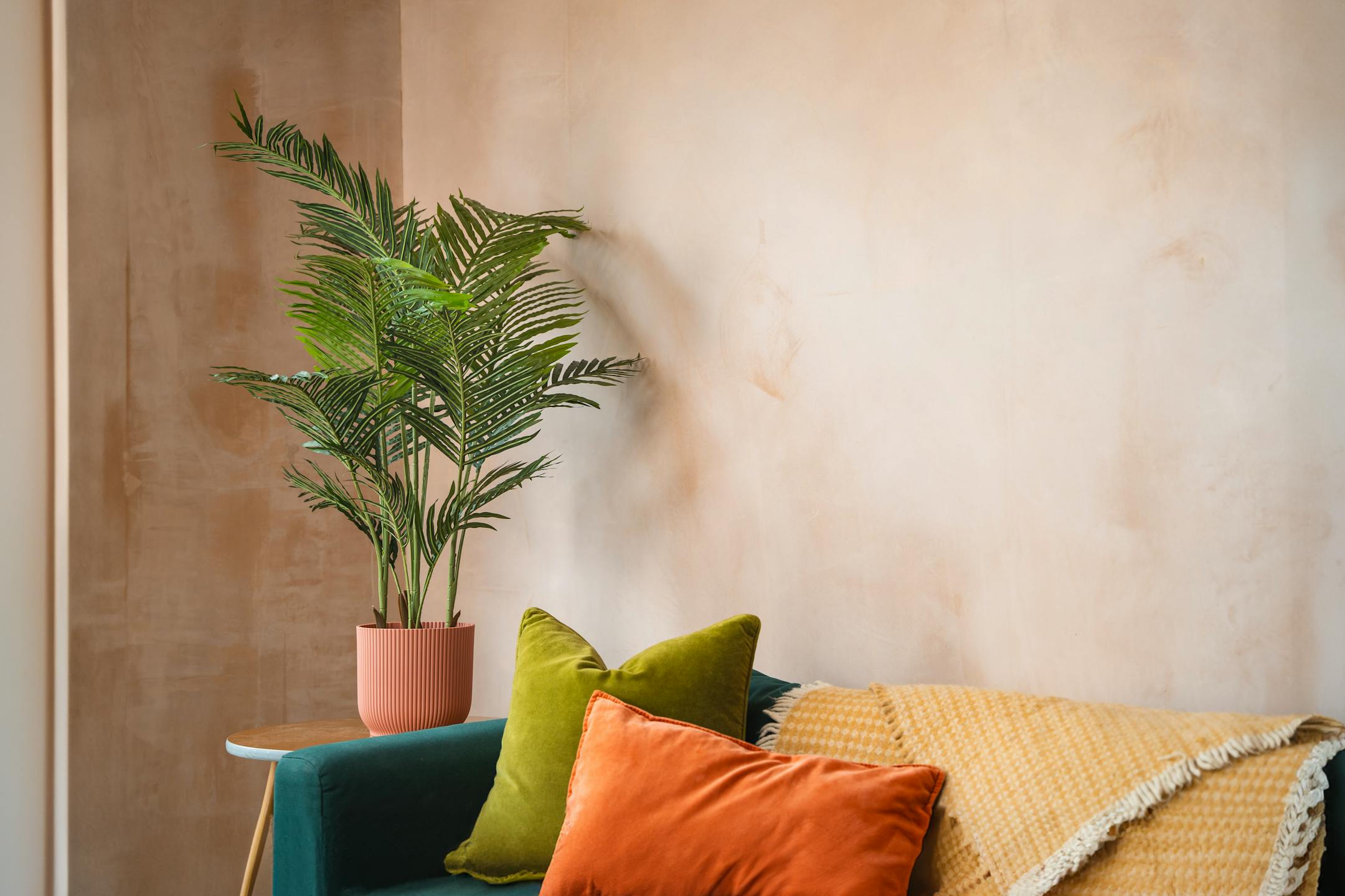 Artificial 125cm paradise palm tree with blue sofa and colourful cushions in living room