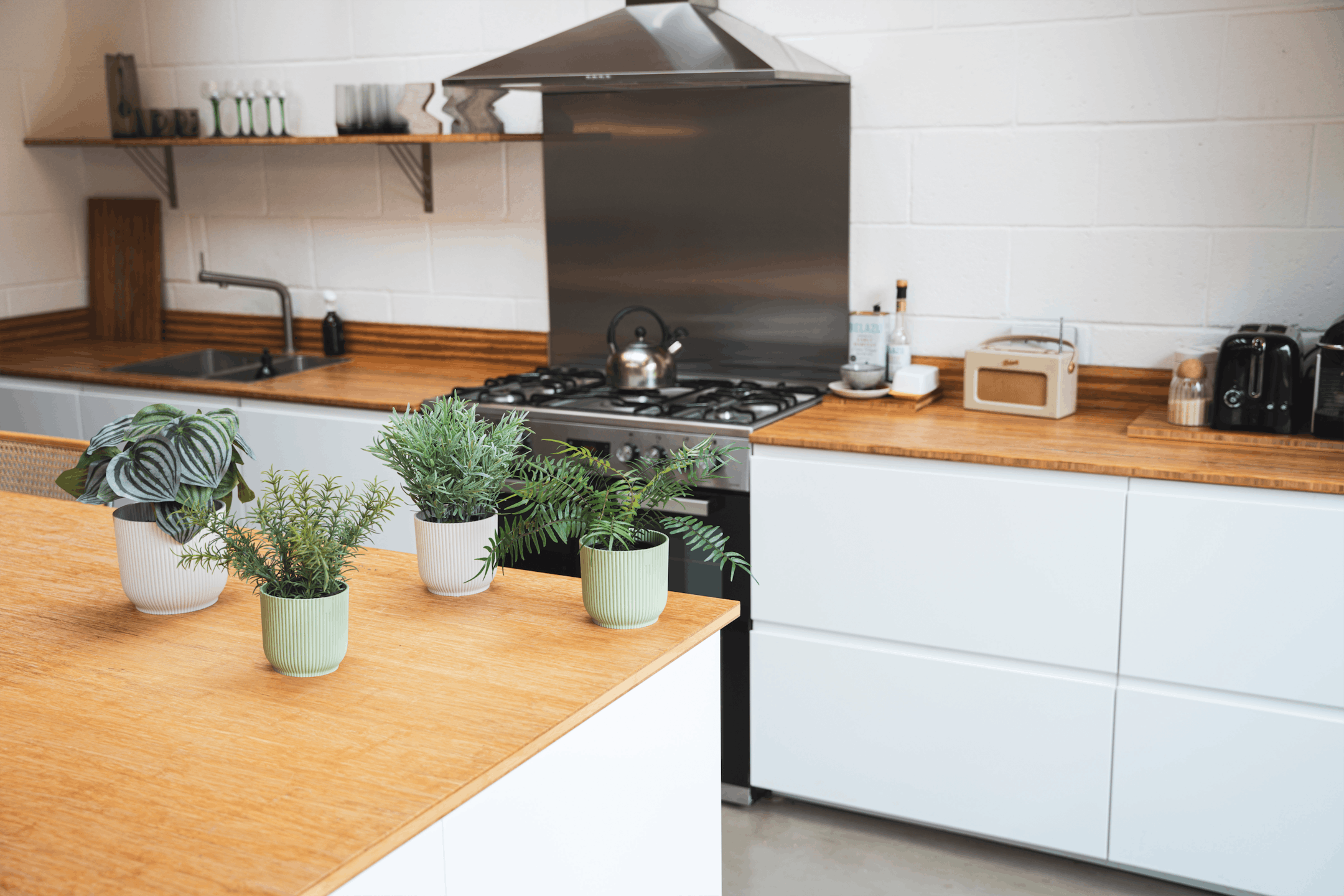 Artificial small plants in pots on wooden kitchen island