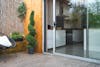 Artificial 150cm cedar spiral topiary tree on garden decking by sliding door