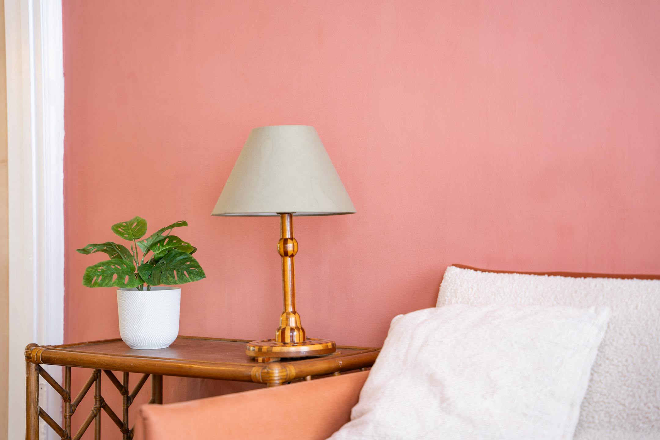 Artificial monkey monstera plant in pink living room with wooden table