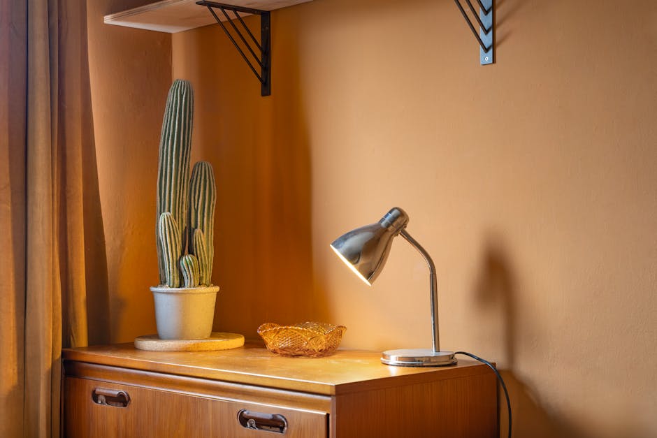 Artificial san pedro cactus in orange bedroom with metal lamp