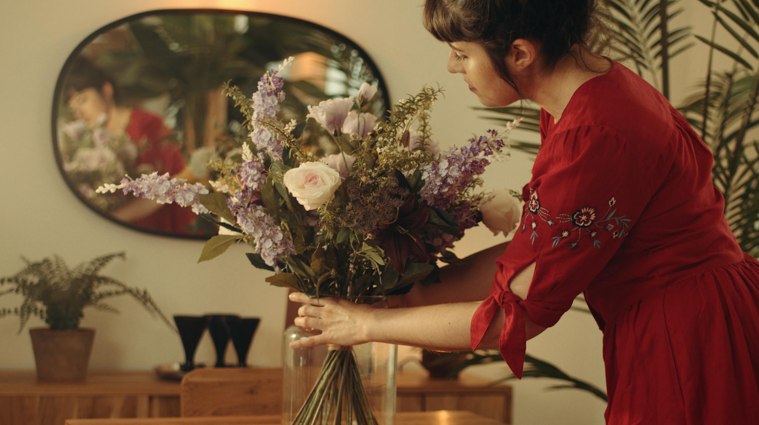 Woman putting artificial amethyst bouquet on table