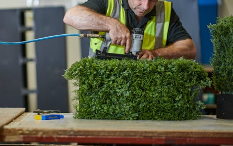 Person building an artificial hedge