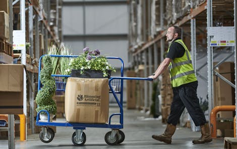 Warehouse operator picking artificial plants Blooming Artificial