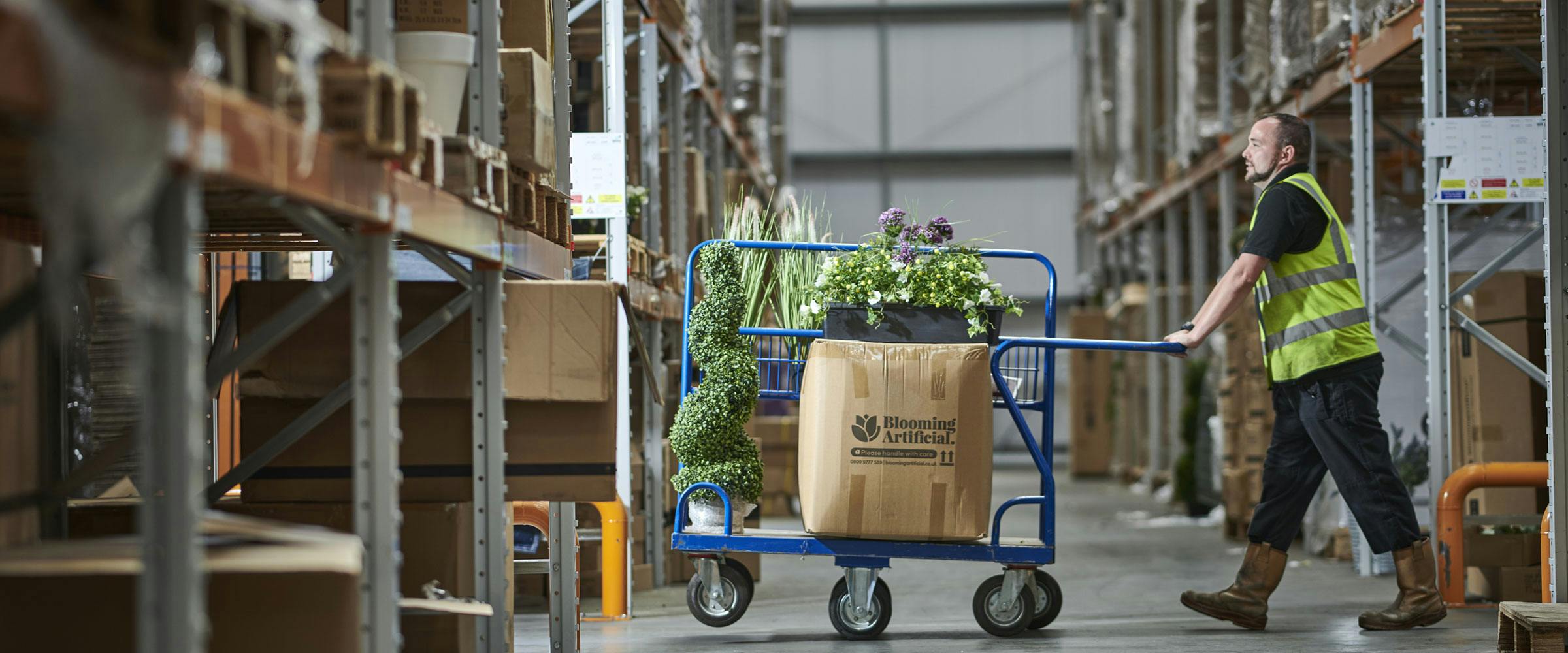 Warehouse operator picking artificial plants Blooming Artificial