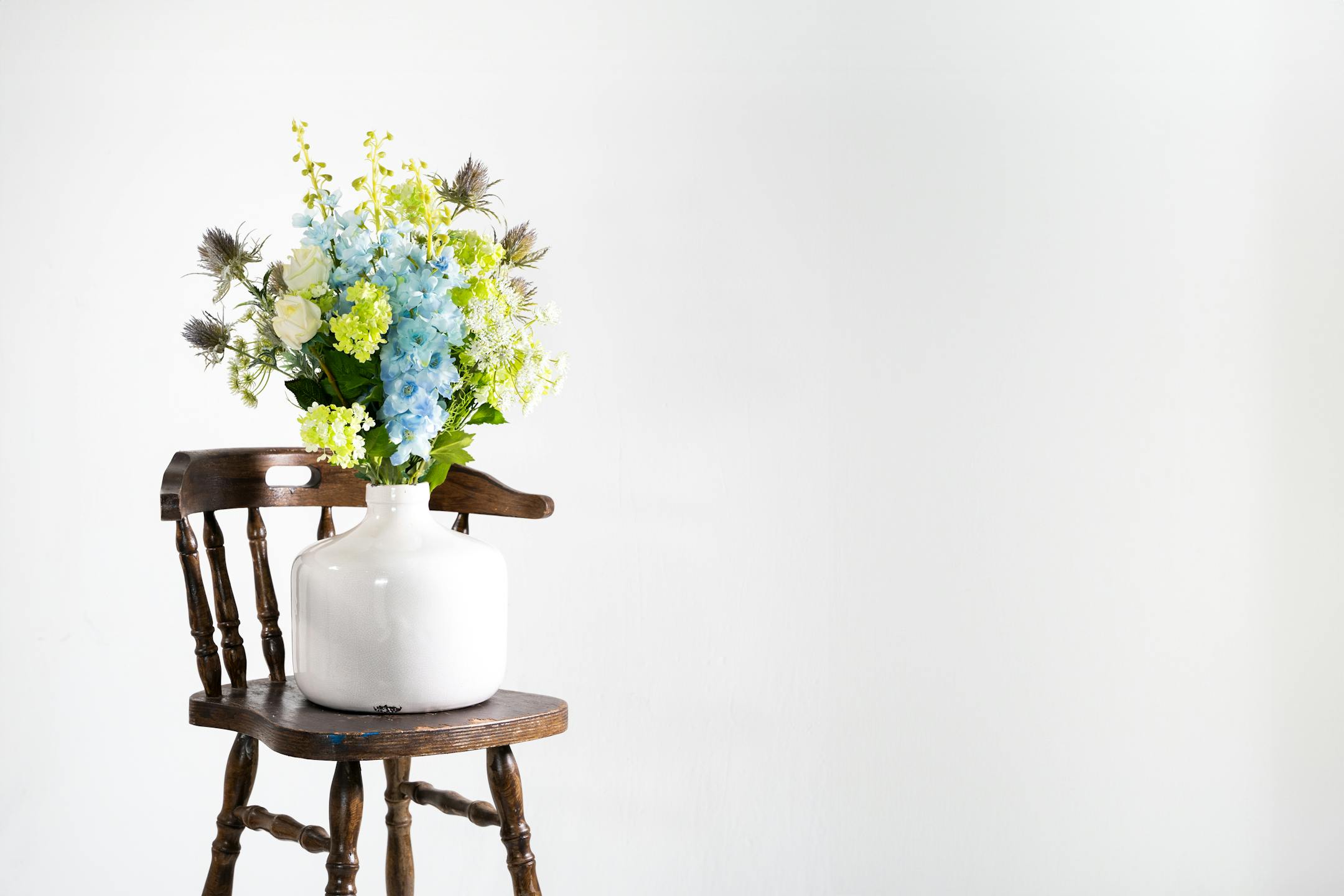 Artificial highland spring bouquet on wooden stool