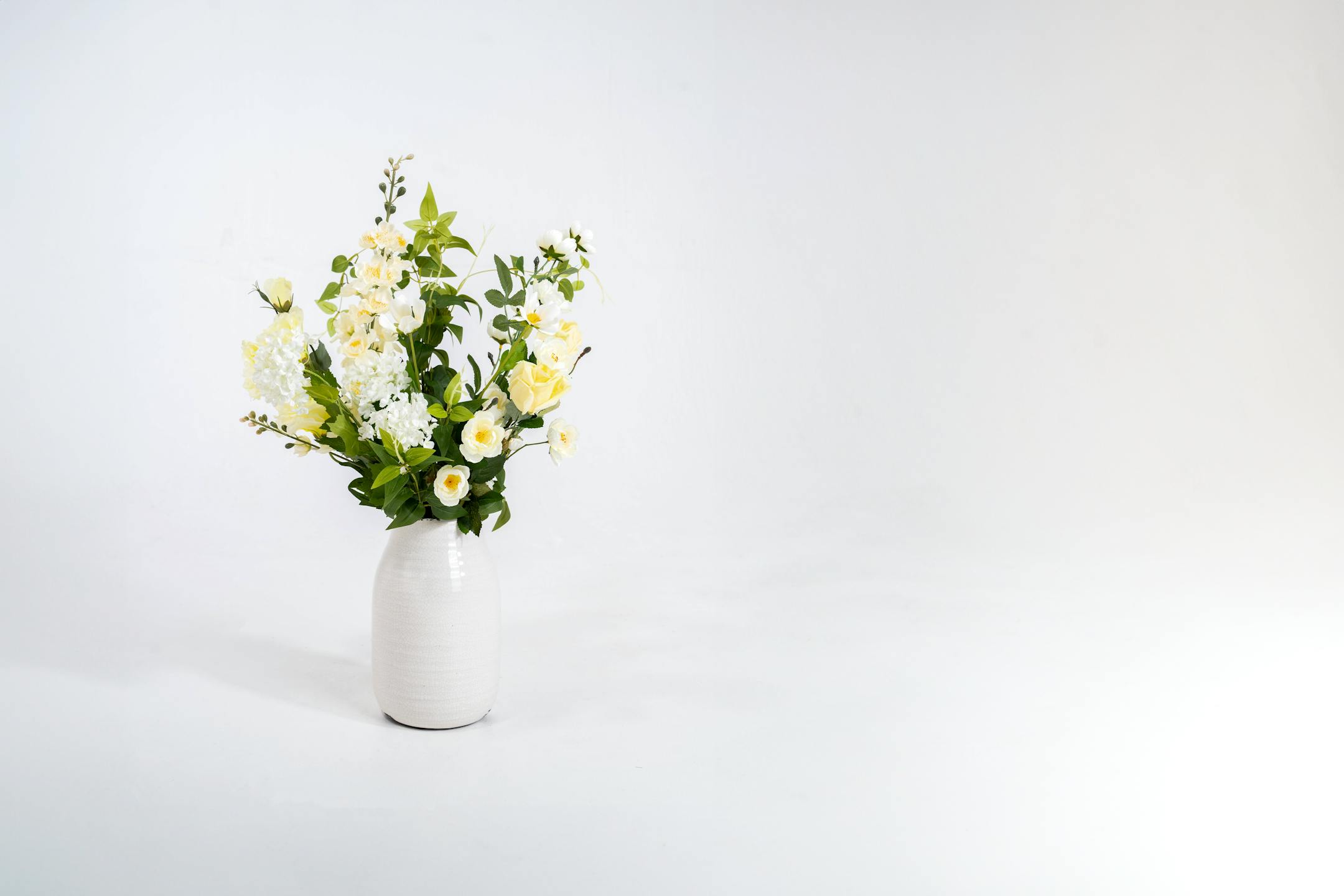 Faux joyful bunch in white ceramic vase