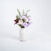 Artificial lilac bunch in white ceramic vase
