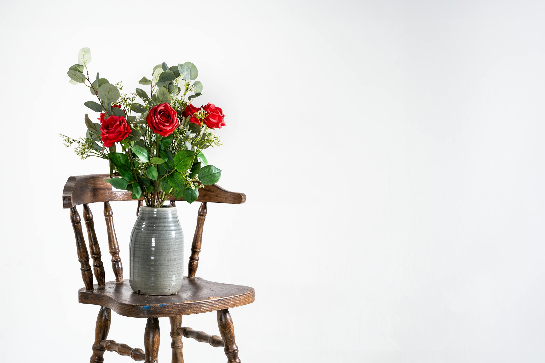 Faux rosa bunch on wooden stool