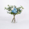 Artificial blue hydrangea bouquet in glass vase