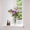 Artificial lilac bunch on window sill