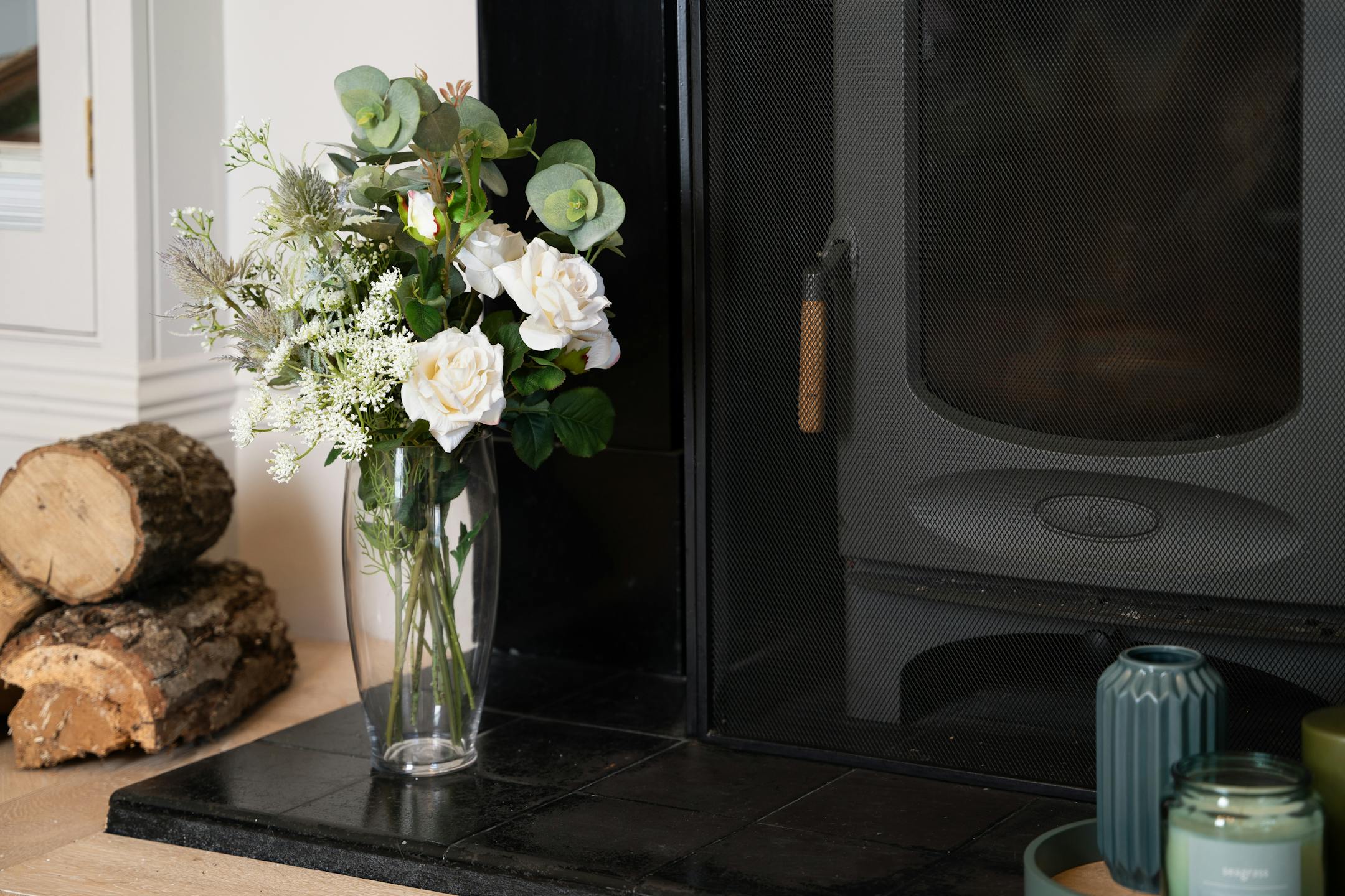 Artificial white enchanting flower bunch next to black fireplace