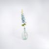 Blue artificial delphinium stem in glass vase