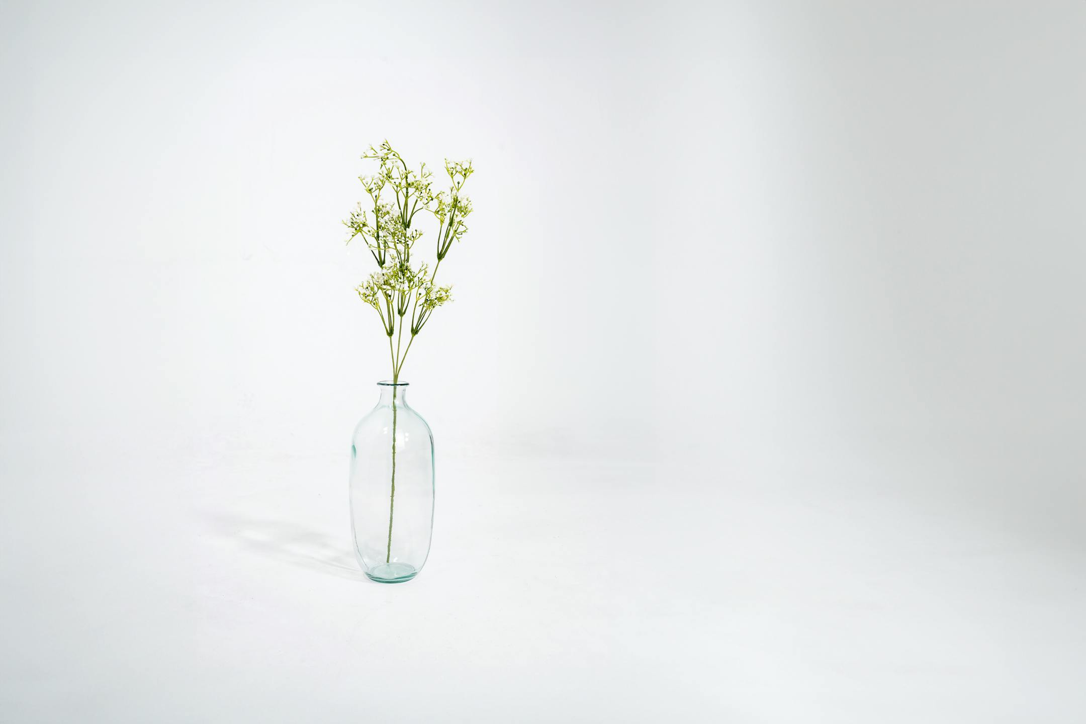 Artificial white gypsophilia spray in glass vase