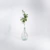 Artificial laurel foliage spray in glass vase