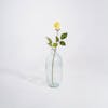 Yellow artificial rose bud stem in glass vase