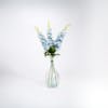 Blue artificial delphinium stems in glass vase