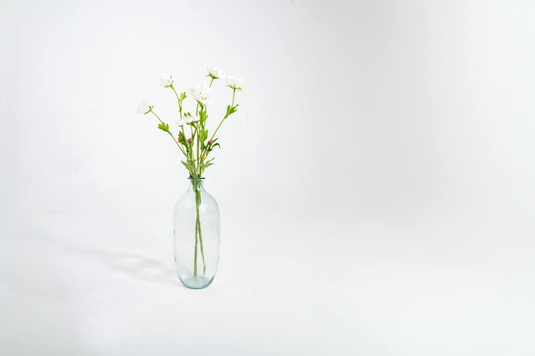 Three faux cosmo stems in glass vase