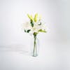 Three artificial oriental lily stems in glass vase