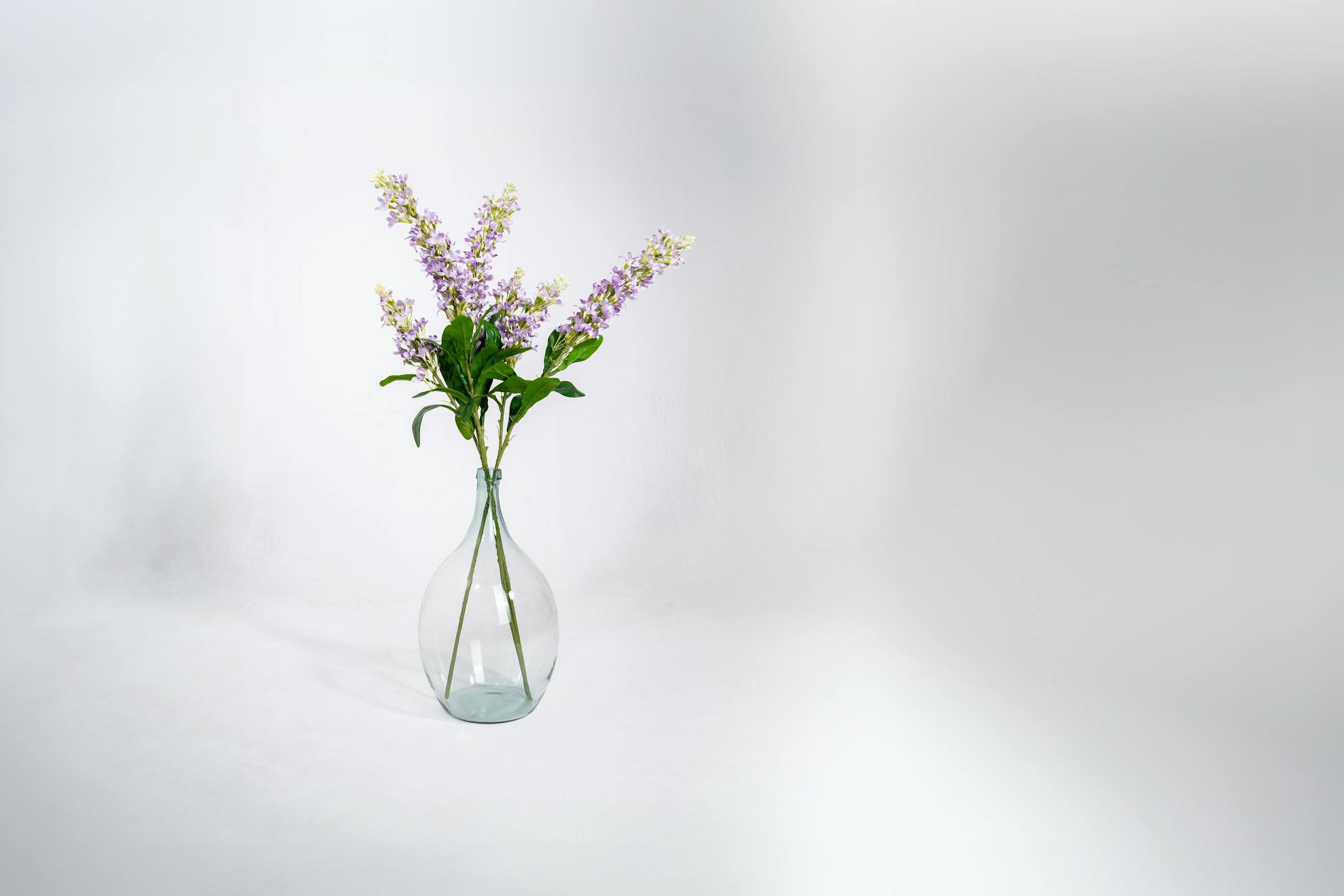 Three artificial stock sprays in glass vase
